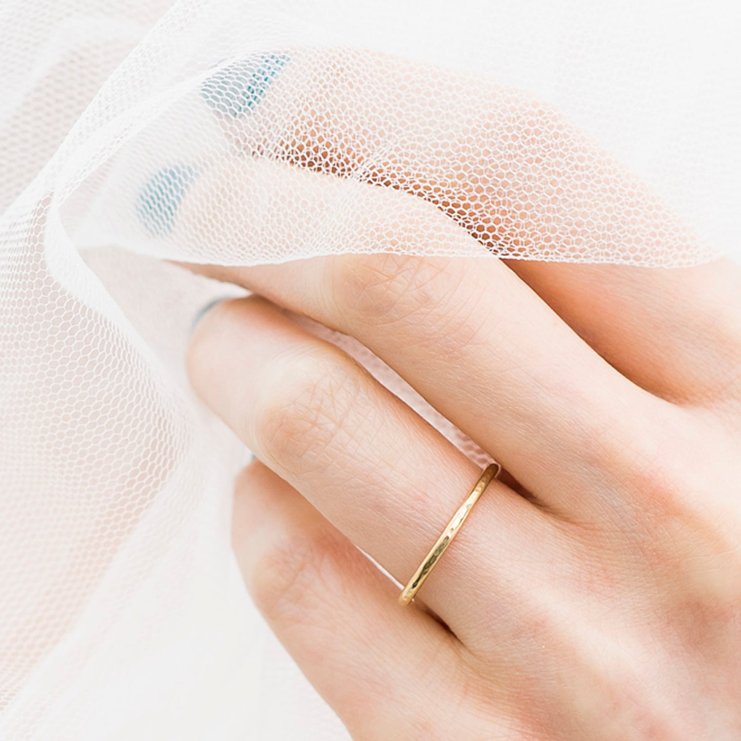 1.5mm 18ct yellow gold band with hammered finish, being worn