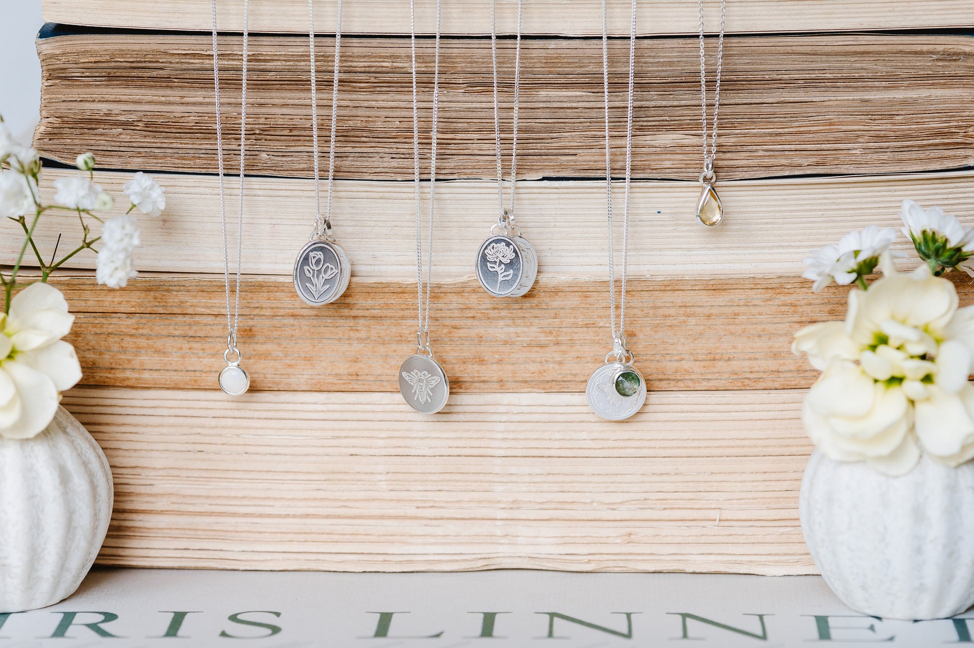 A selection of sterling silver necklaces, some engraved with patterns and some with gemstones. 