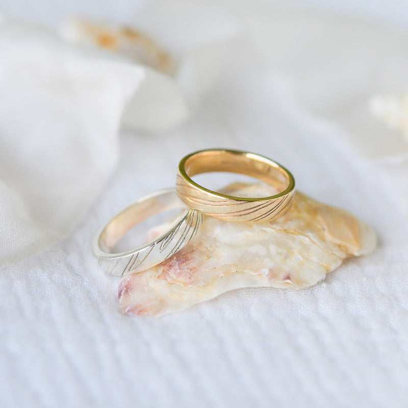 Two wedding rings stacked on a seashell, Sand Rings