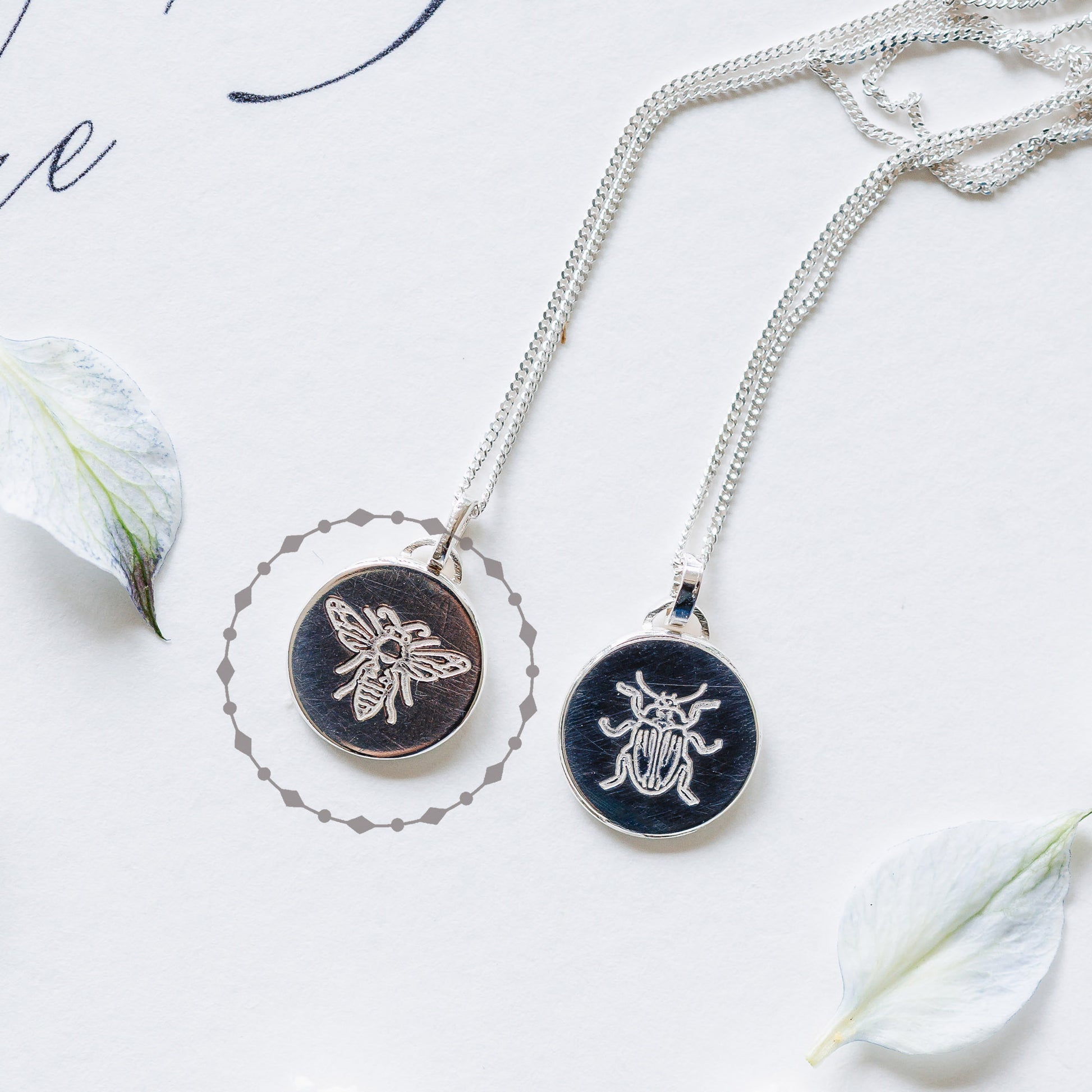 Two sterling silver necklaces, one with a bee and one a beetle. 