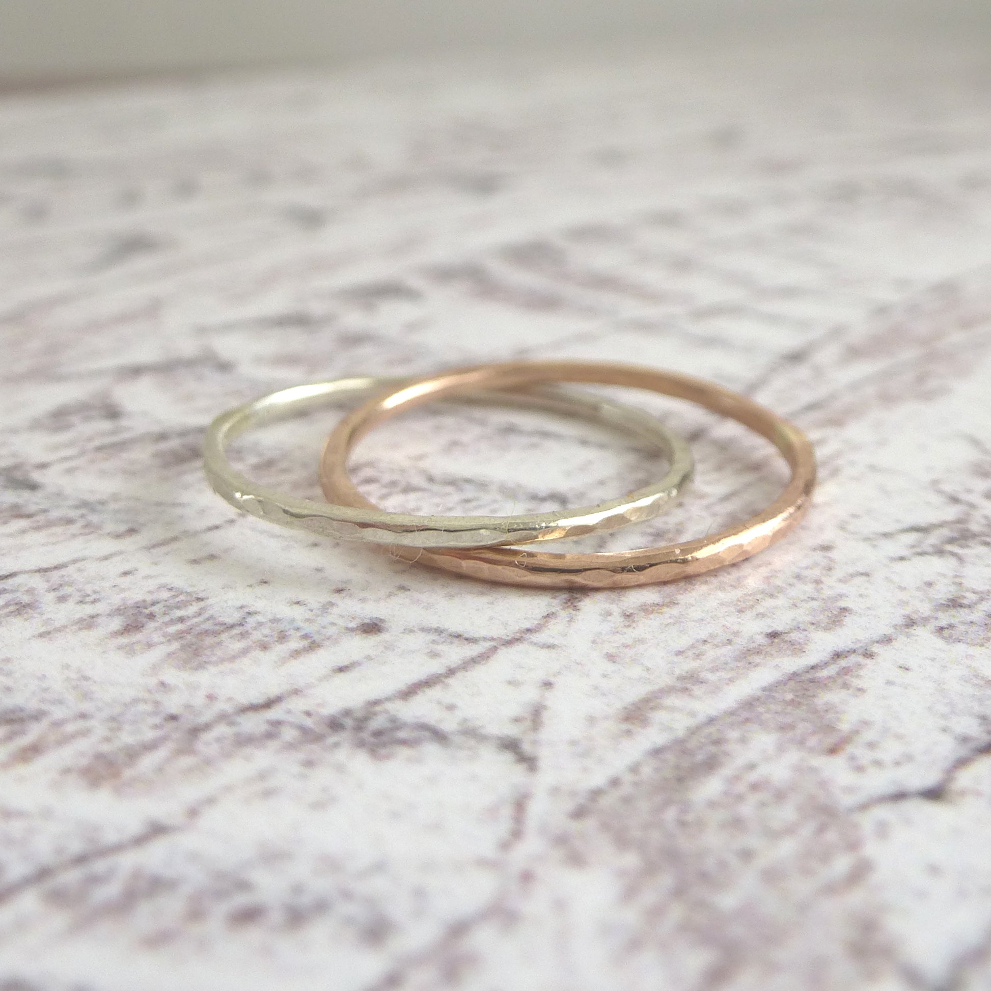 A pair of joined or russian wedding ring style bands in 9ct white and rose gold, with a hammered finish