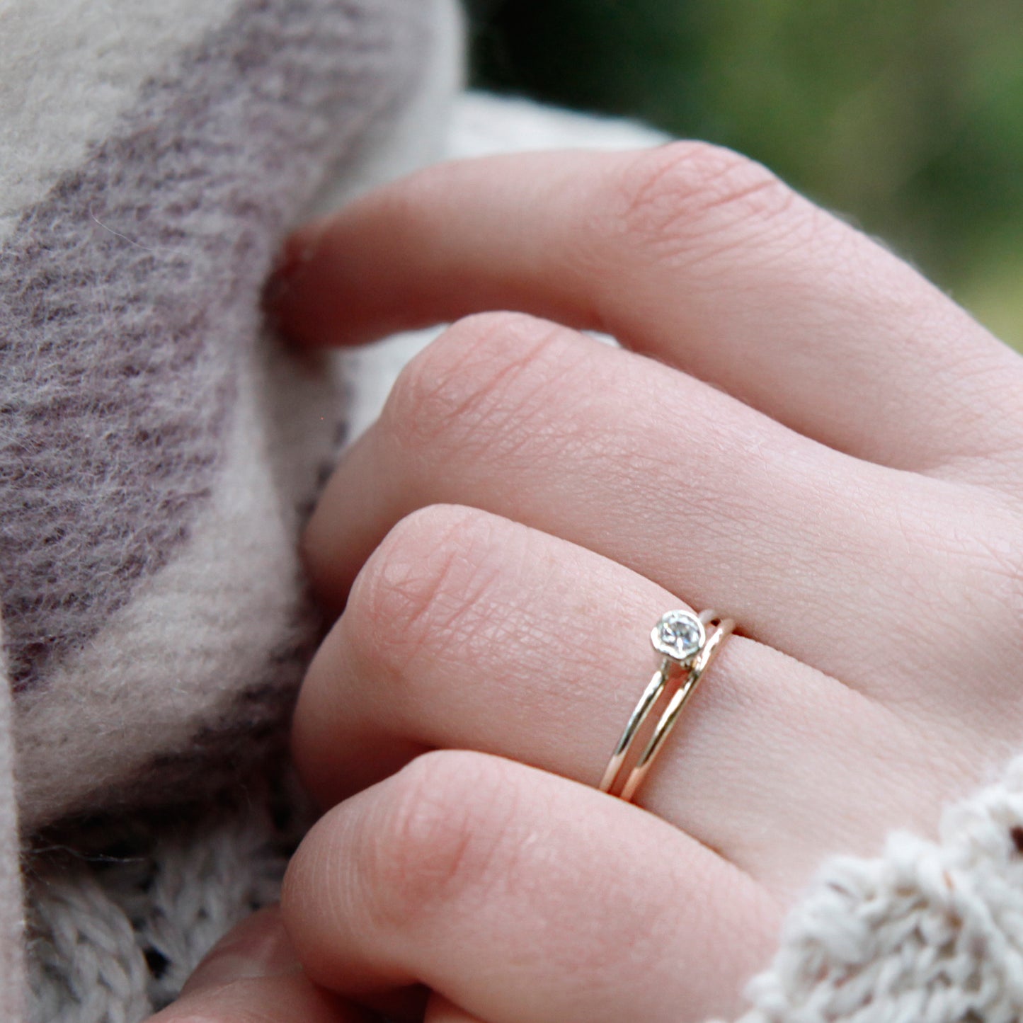 A hand wearing a 1.2mm stone set ring, and a 1.2mm band