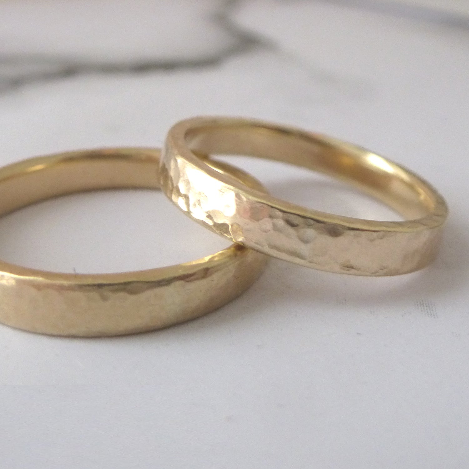 A pair of wedding bands in 9ct yellow gold, recycled, hammered finish
