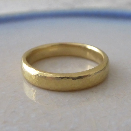 A slim band ring in 18ct yellow gold with a smooth finish, displayed on a white surface.