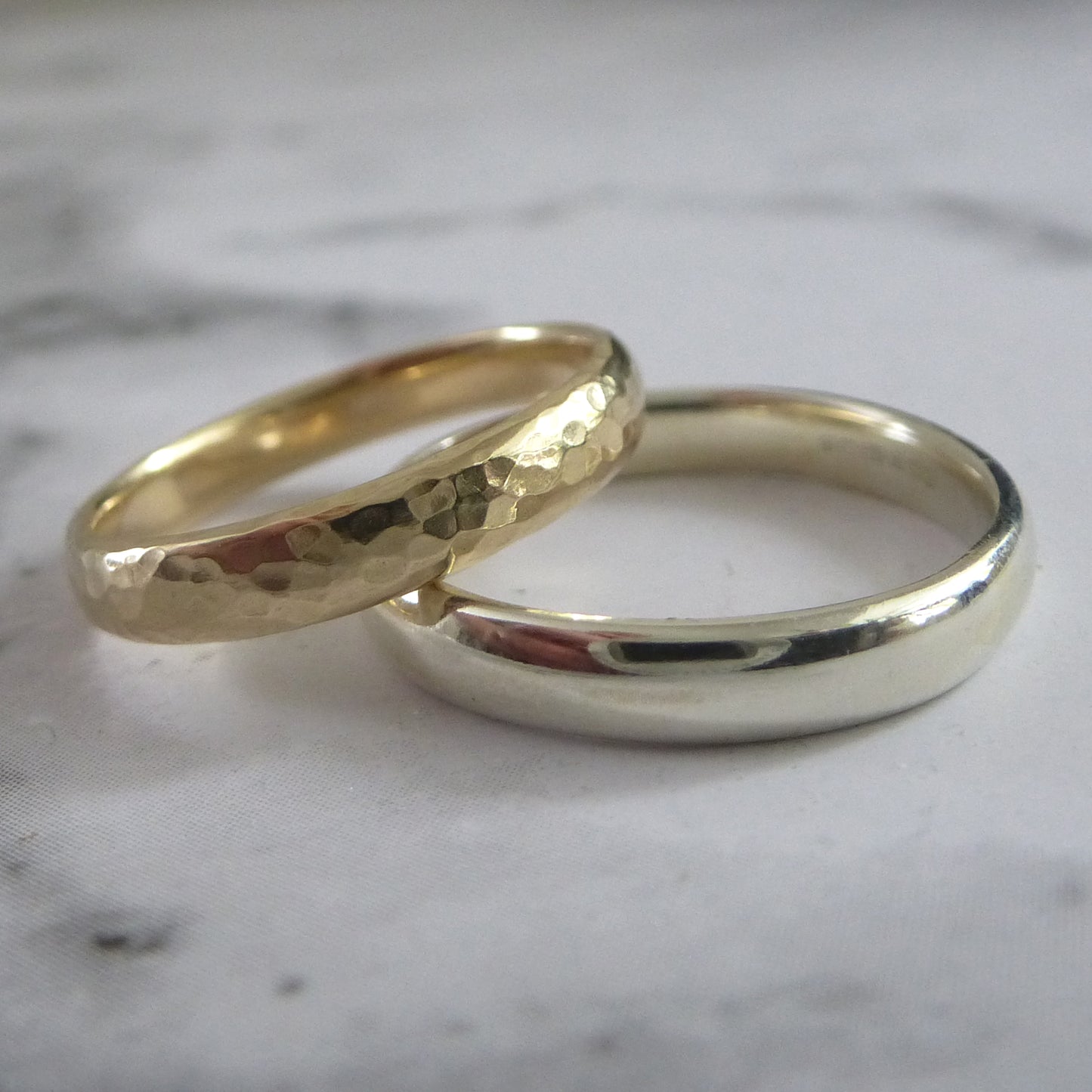 A pair of handmade wedding bands, 9ct yellow gold hammered and 9ct white gold smooth