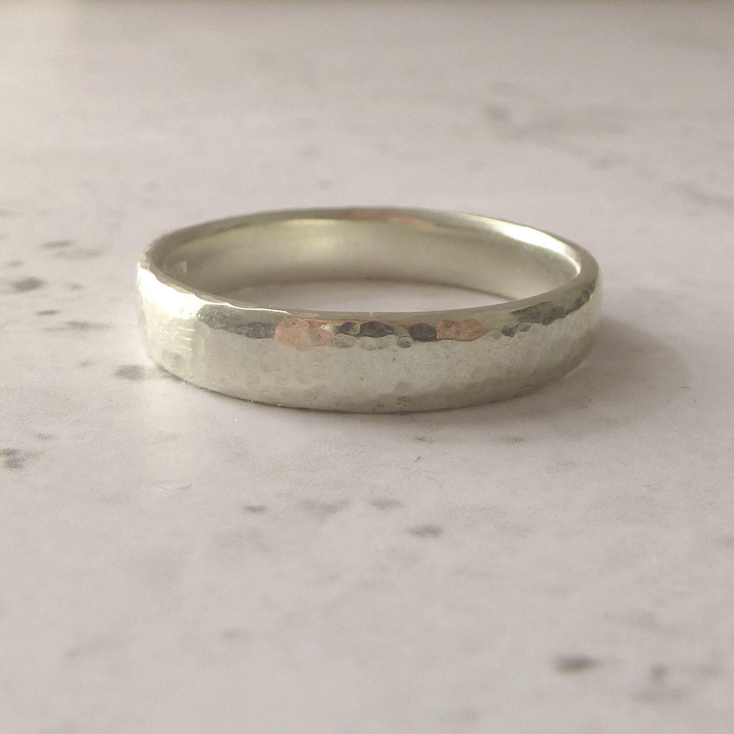 hand made wedding band in 9ct white gold, hammered finish, soft modern court shape