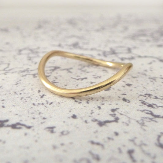 A 9ct gold wishbone ring with a 1.5mm diameter, displayed on a textured surface.