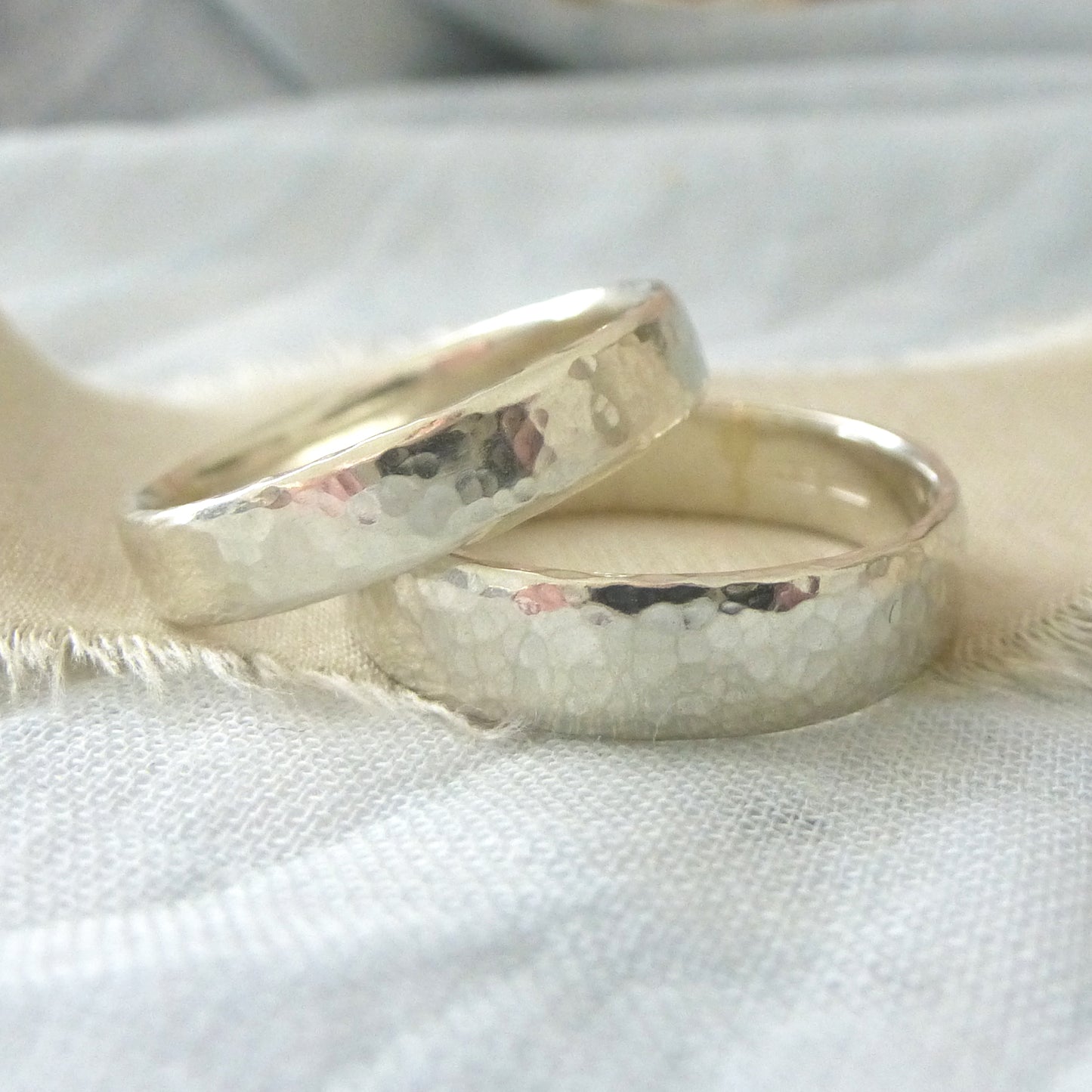 A pair of handmade wedding rings in 9ct white hammered gold, 100% recycled gold, Upper band 4mm, lower band 5mm
