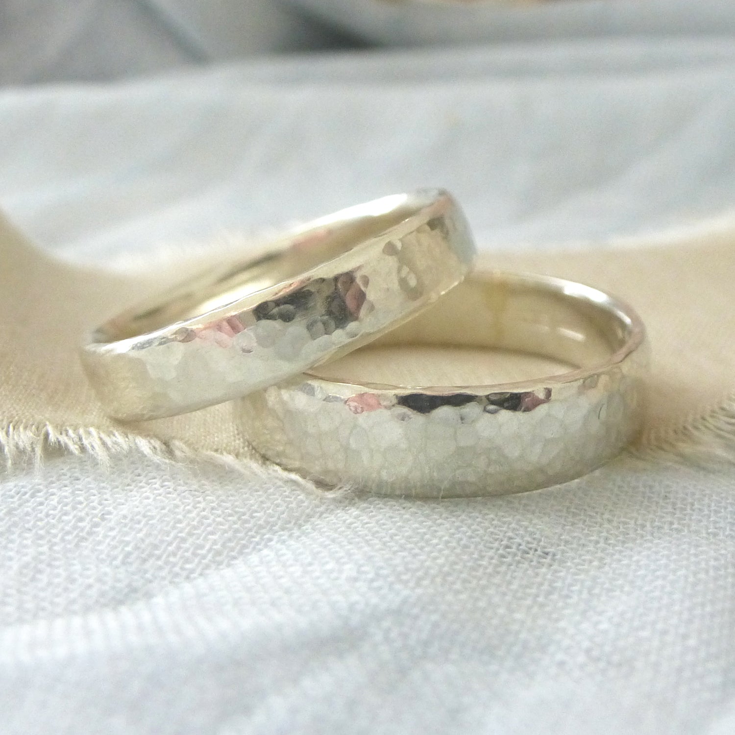 A pair of handmade wedding rings in 9ct white hammered gold, 100% recycled gold, Upper band 4mm, lower band 5mm