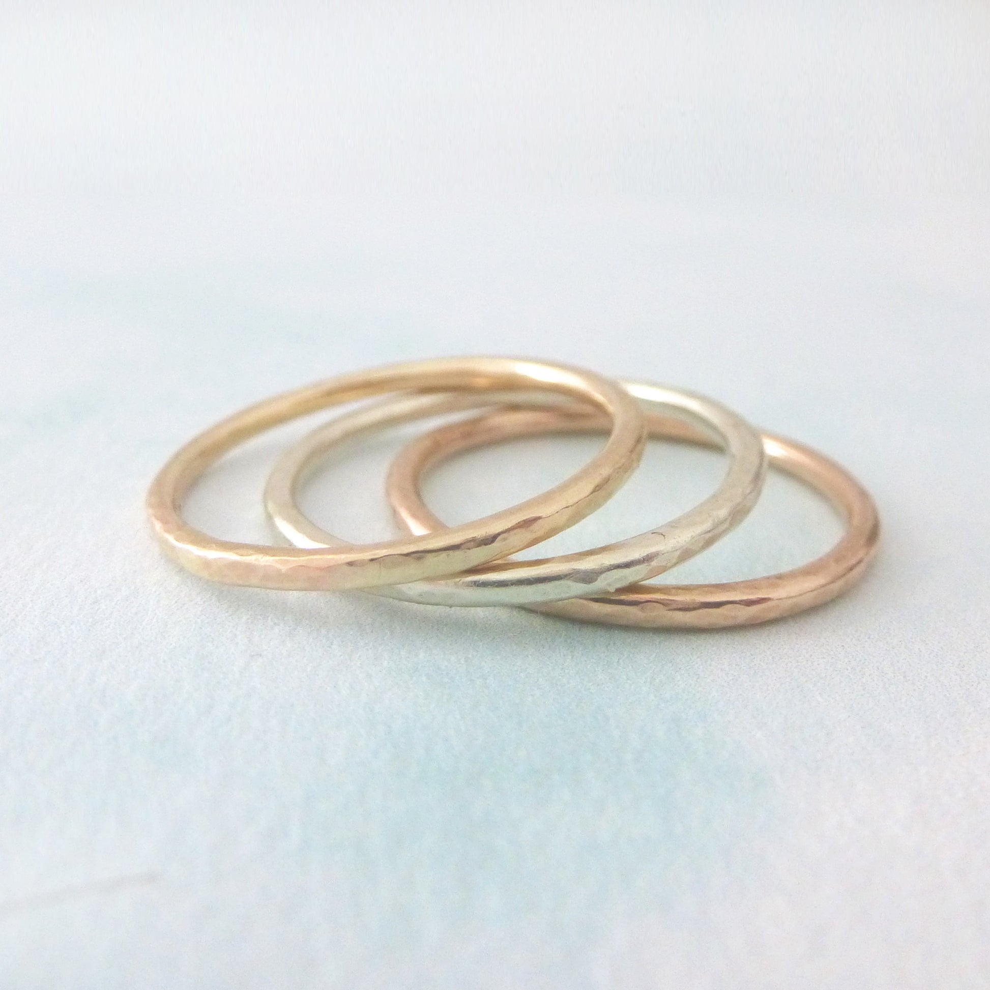 A stack of 3 slim bands in 9ct gold, one yellow, white and rose.