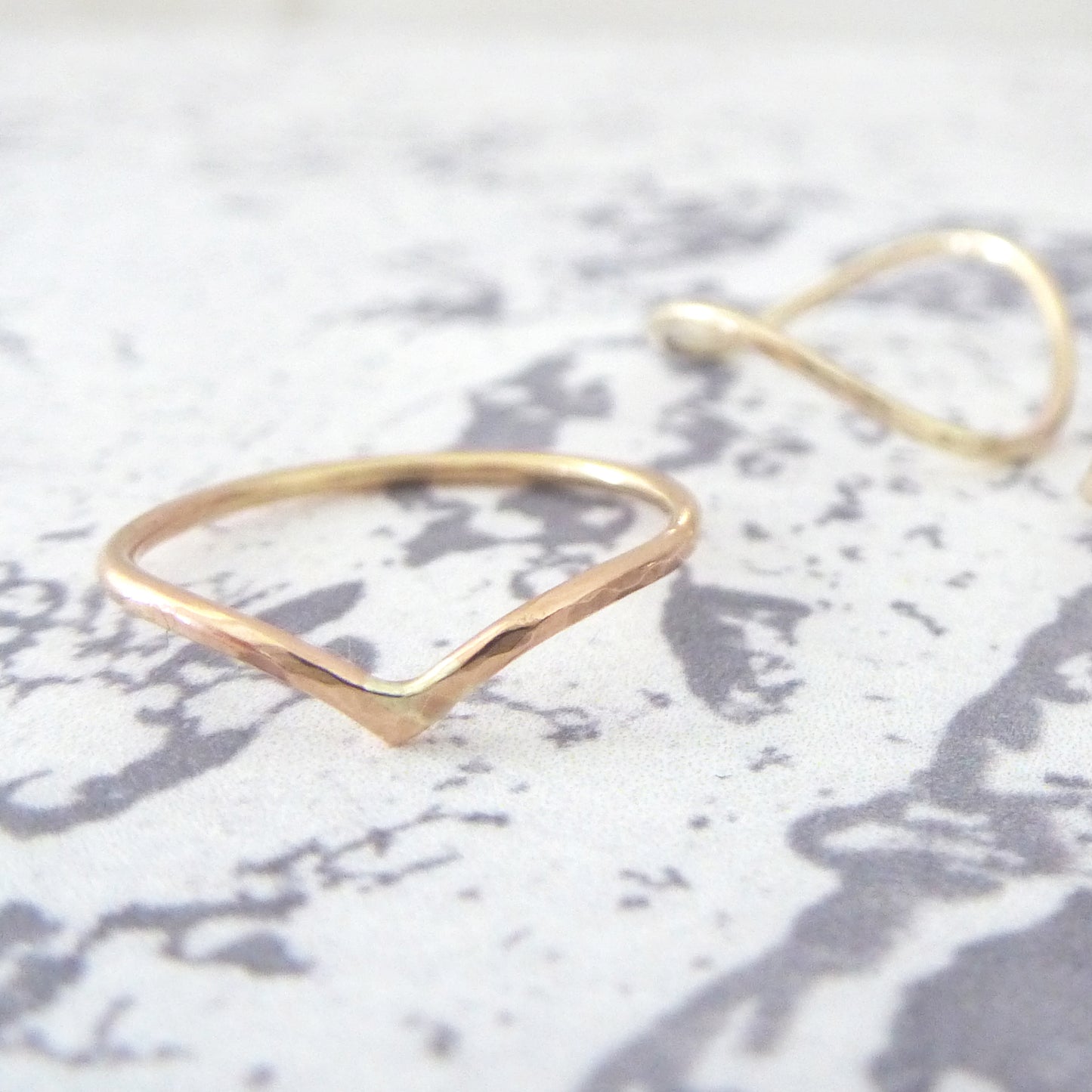 Slim wishbone in 9ct rose gold, with rocking wishbone in background.
