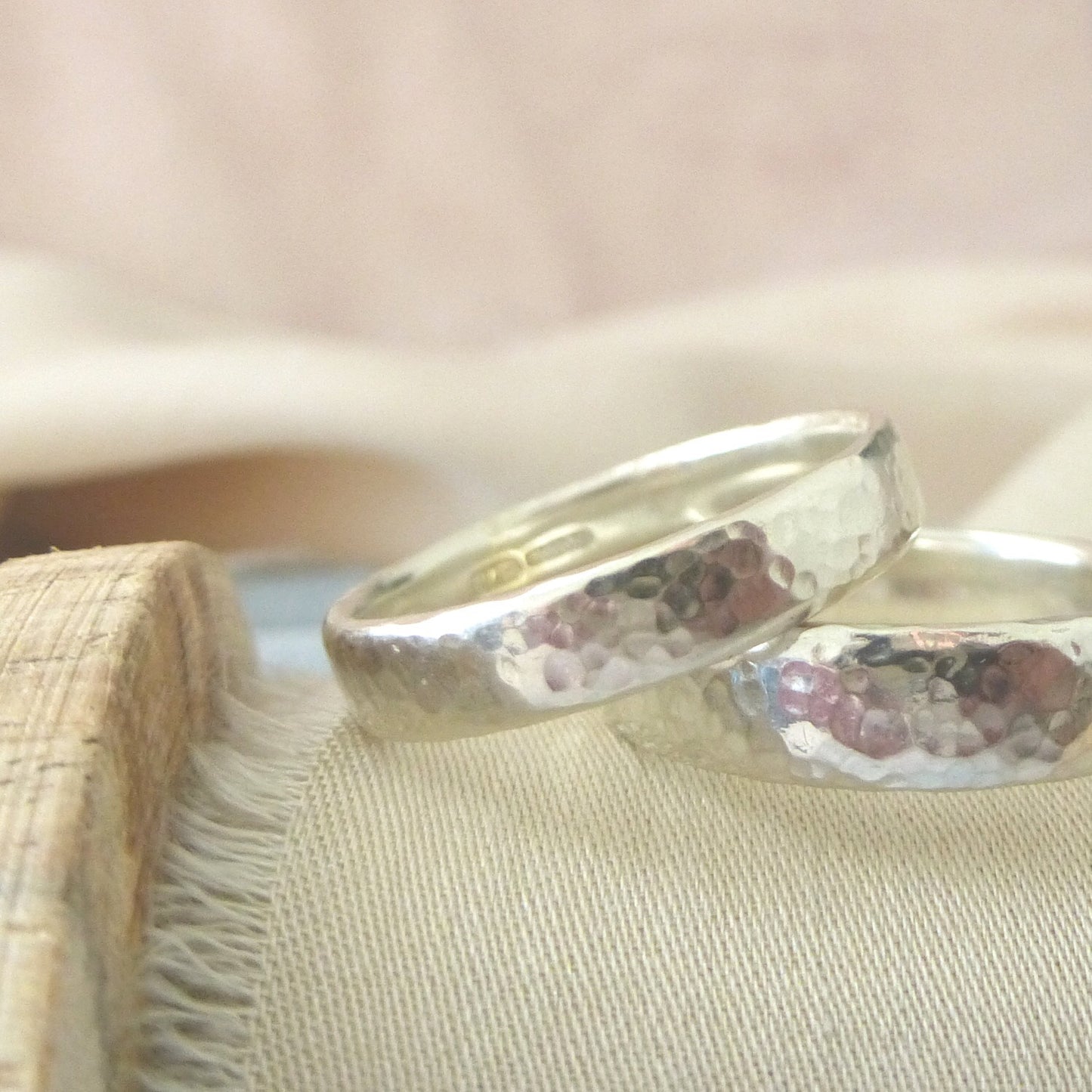 Close up of a 4mm and 5mm hammered wedding band in recycled 9ct white gold