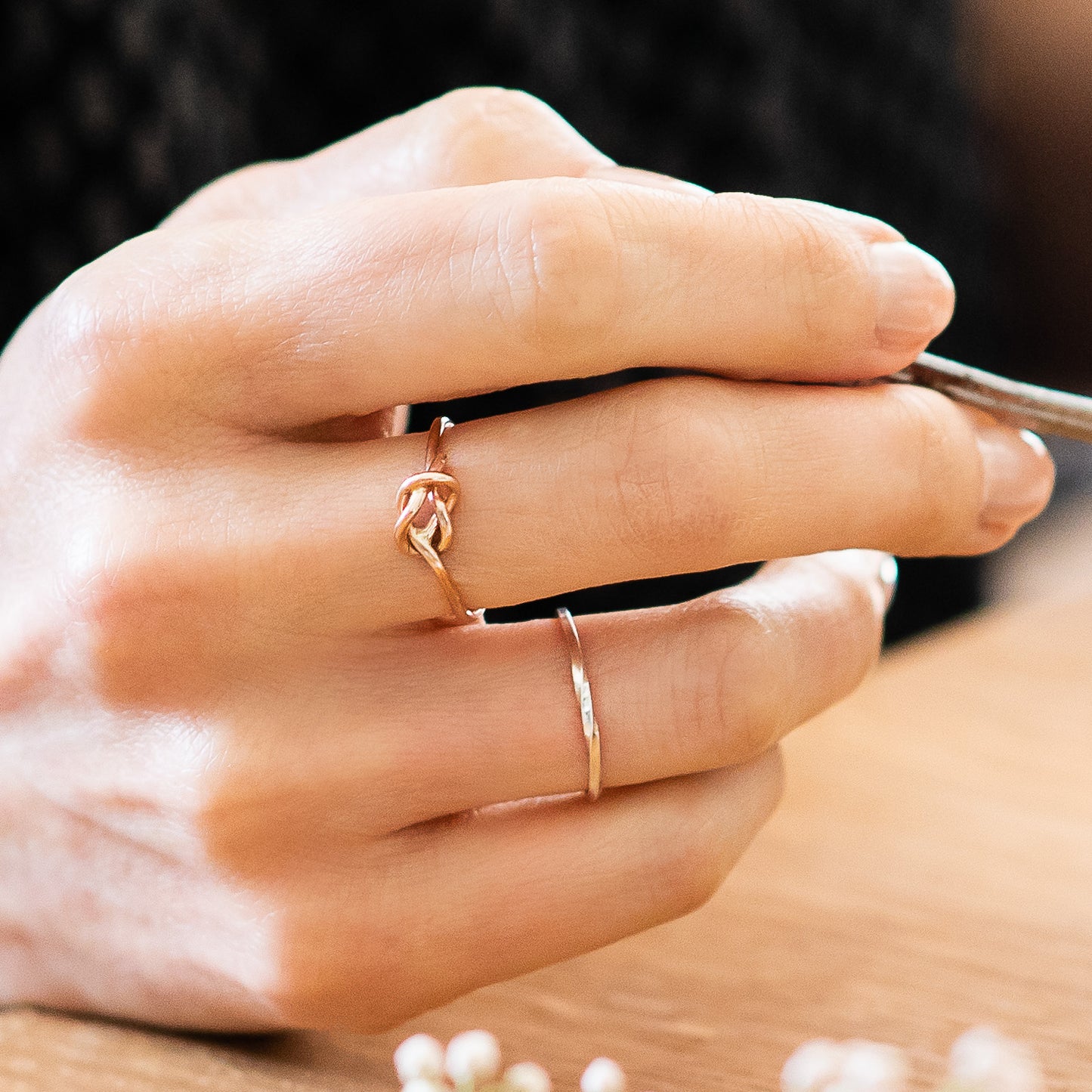 slim rose gold knot ring being worn, close up