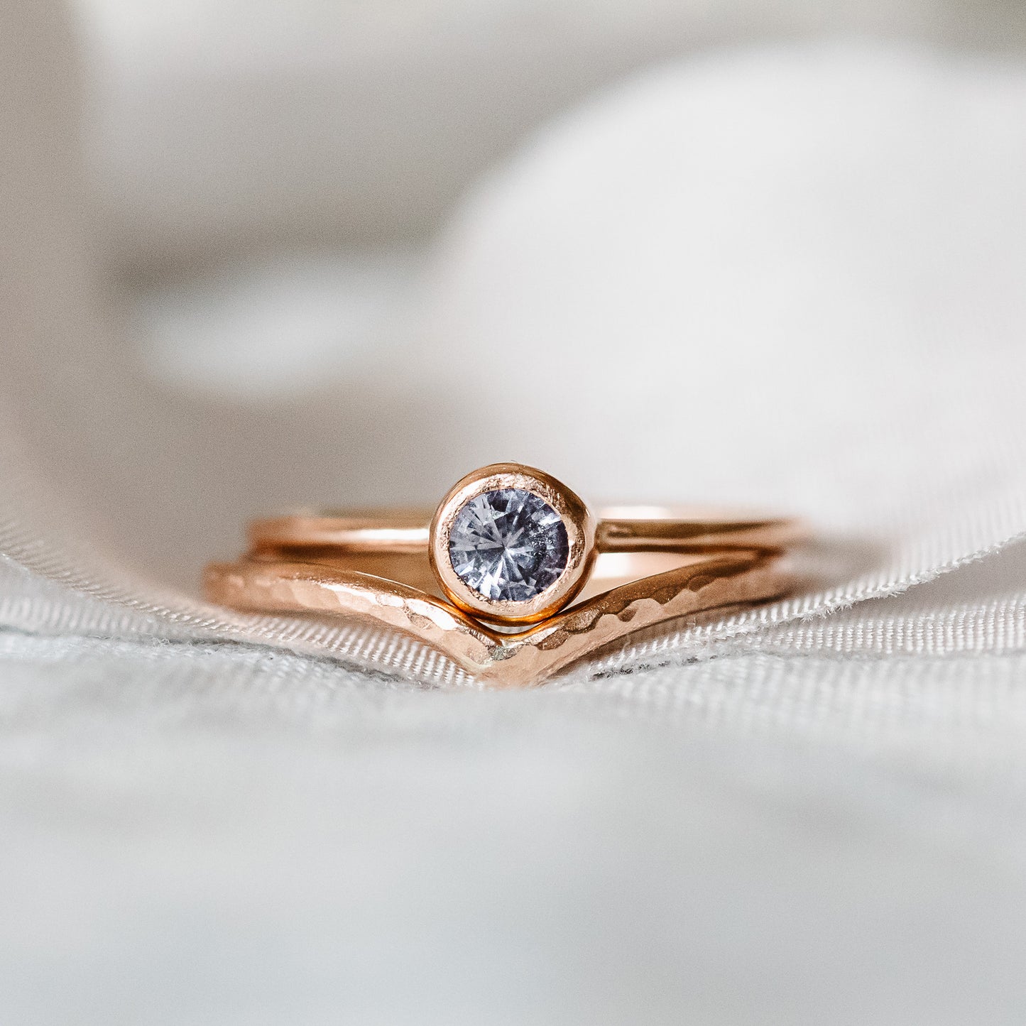 9ct rose gold wishbone ring, and spinel ring, close up setting on ribbon